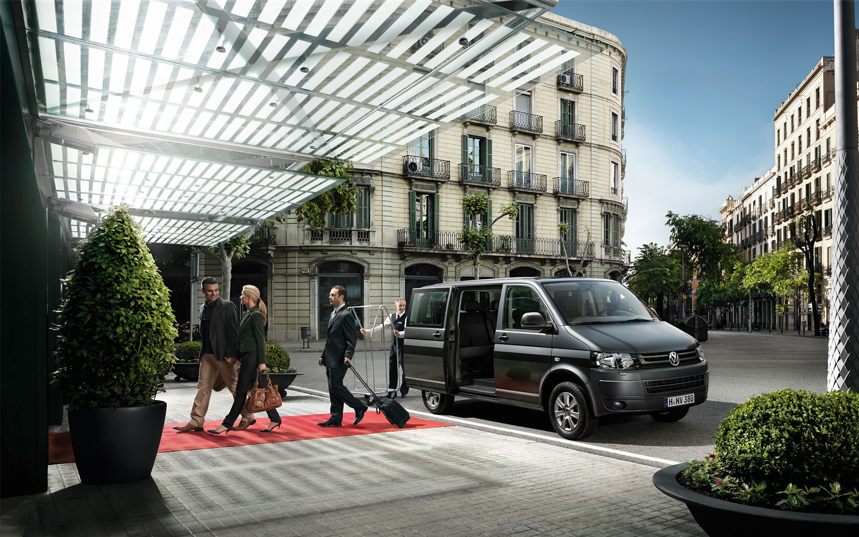Guests loading luggage into a taxi outside a hotel